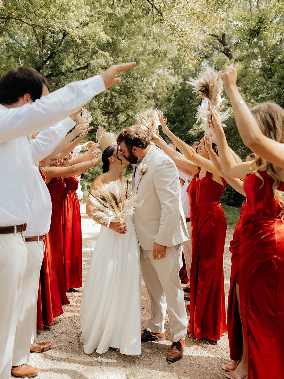 Bride and groom kissing surrounded by wedding party at The Era in Iowa