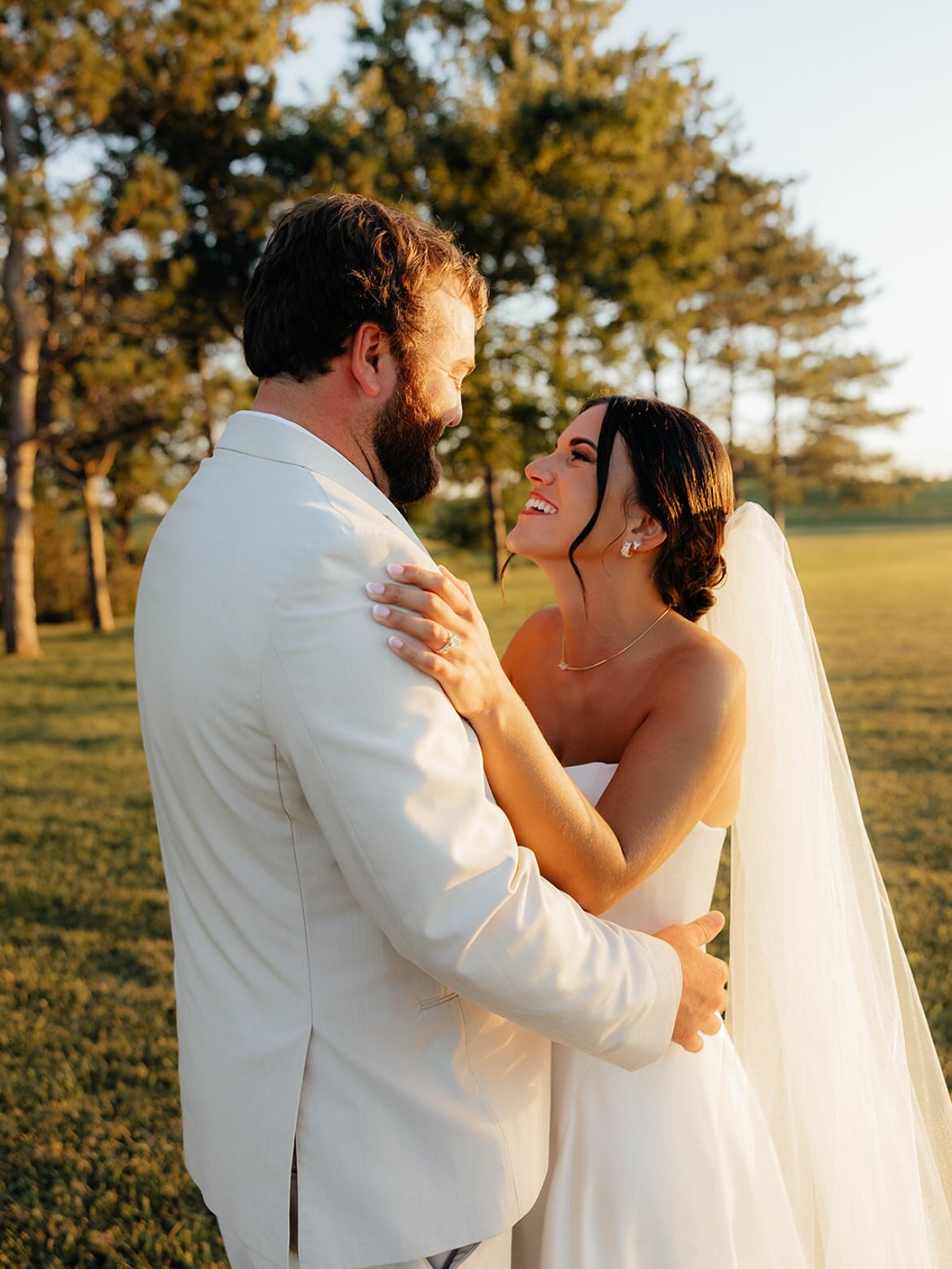 Bride and groom embracing at golden hour at an intimate Iowa wedding