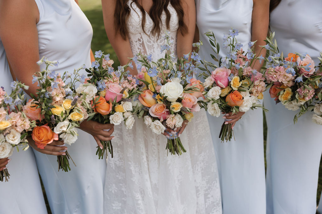 Bride and bridesmaids holding colorful wedding bouquets at an intimate Iowa wedding