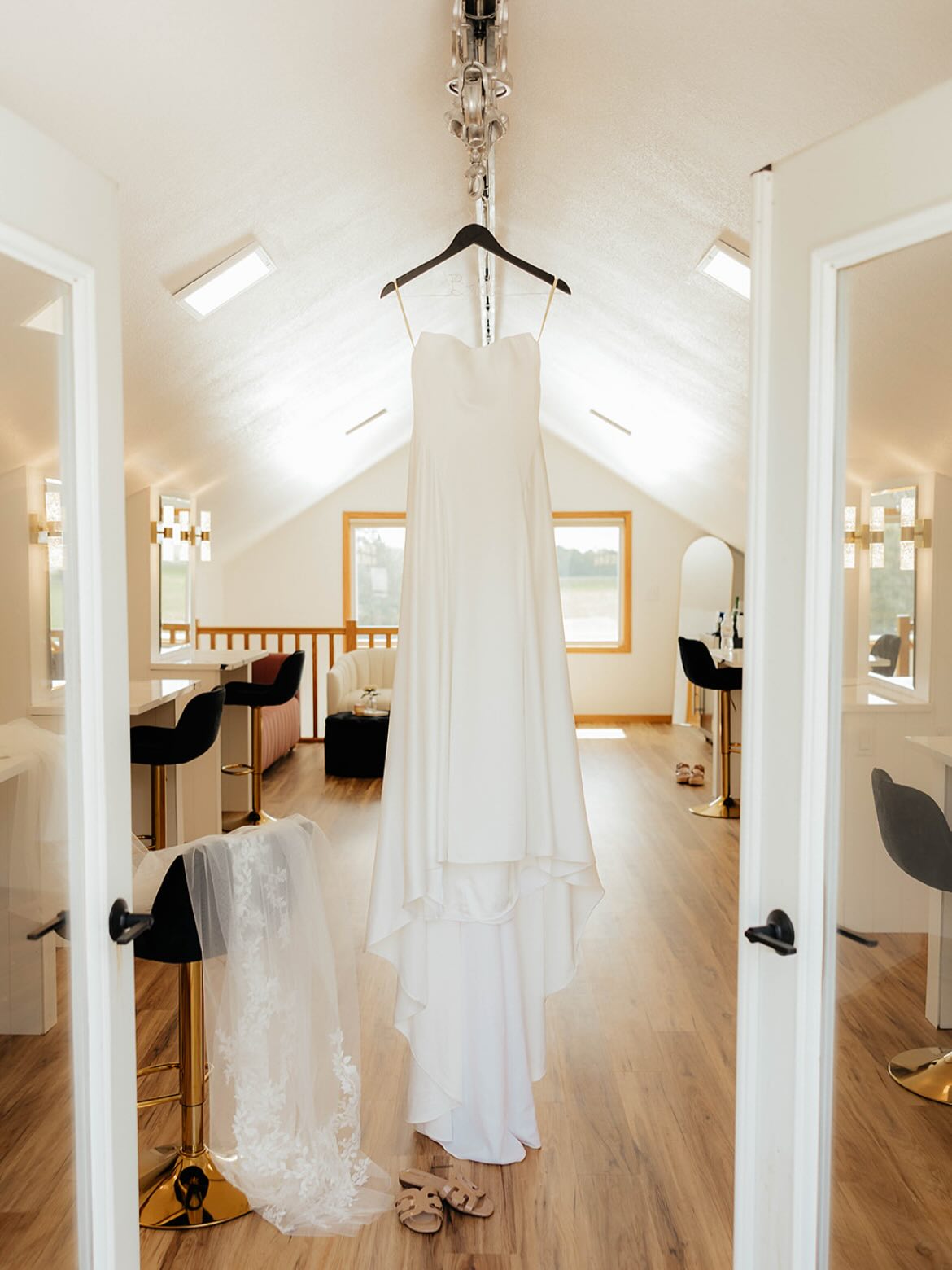 Wedding dress hanging in a quiet, empty bridal loft before the ceremony