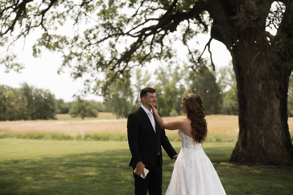 Bride and groom sharing a quiet moment together under an oak tree, away from wedding guests
